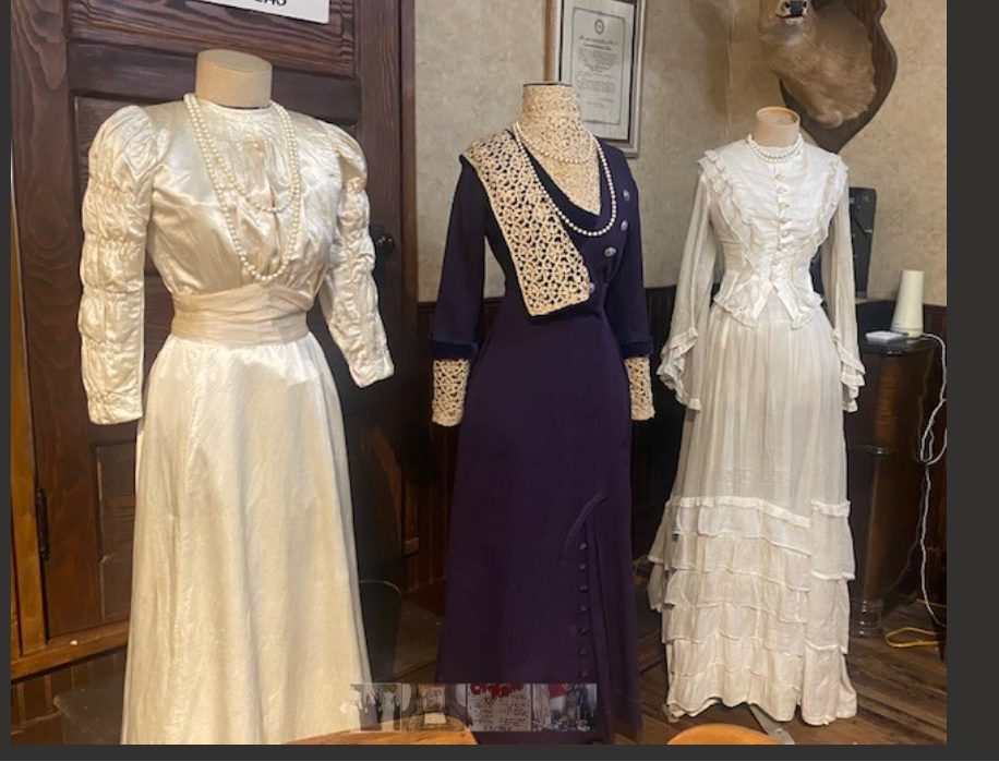 Victorian-era gowns on display in the clothing shop